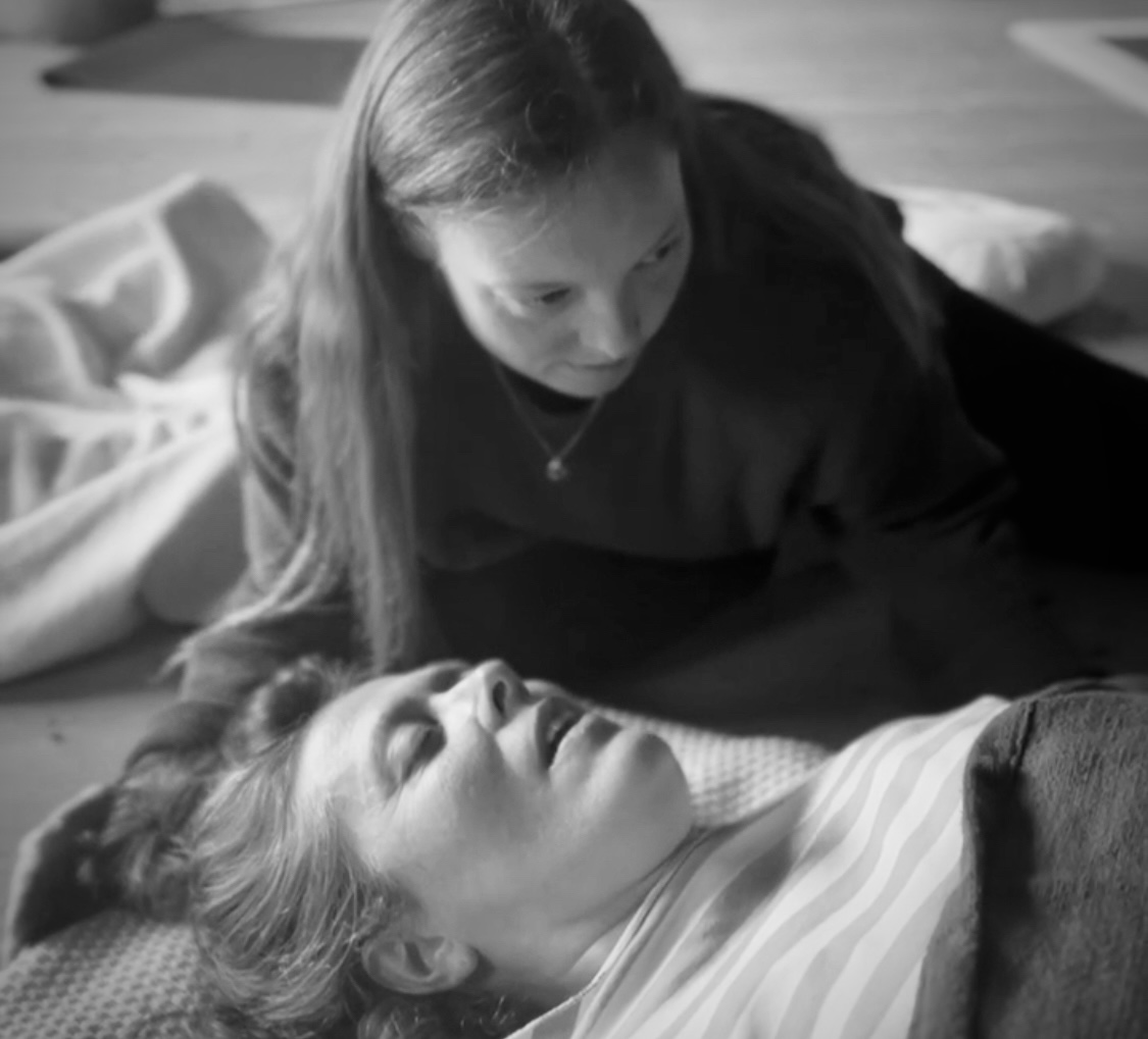 Frau macht sitzend Breathwork mit Händen vor Herz